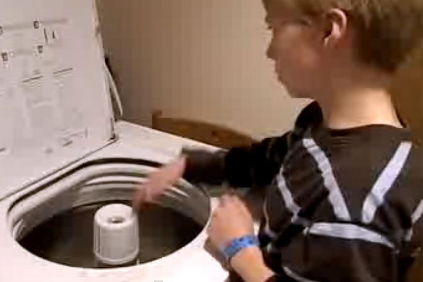 niño toca la bateria con una lavadora